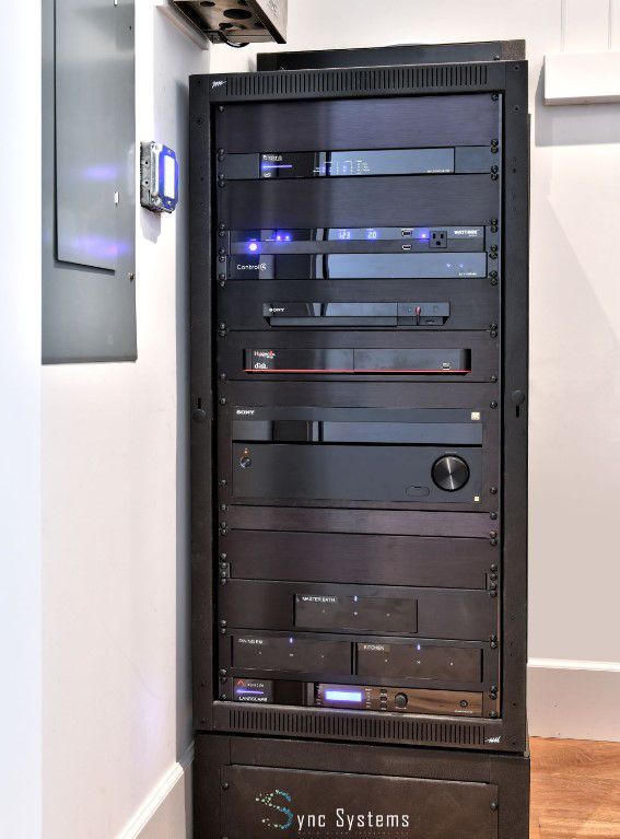 A large cabinet filled with various types of electronics, including audio and video equipment, gaming consoles, and accessories.