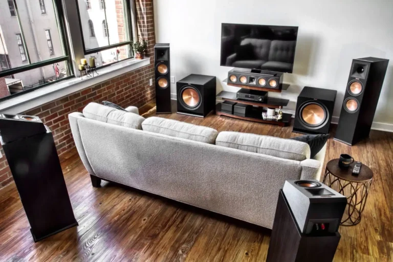 A living room setup with a couch, speakers, and a television, highlighting potential home theater errors to avoid.