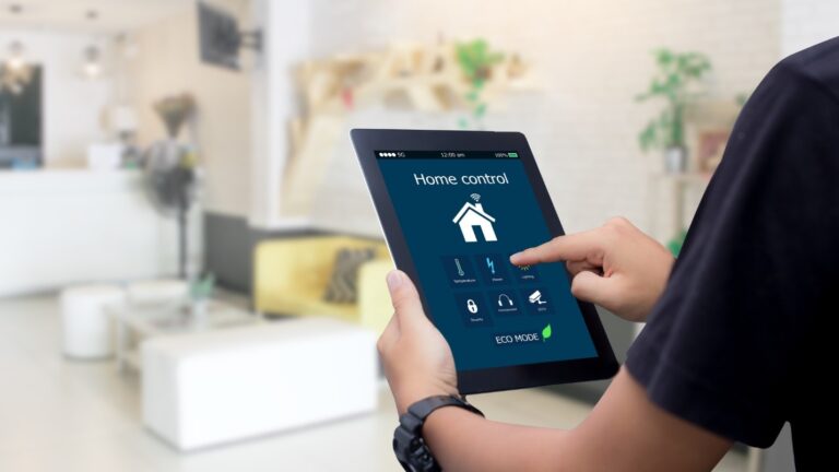 A person uses a digital pad to adjust the settings in their smart home.