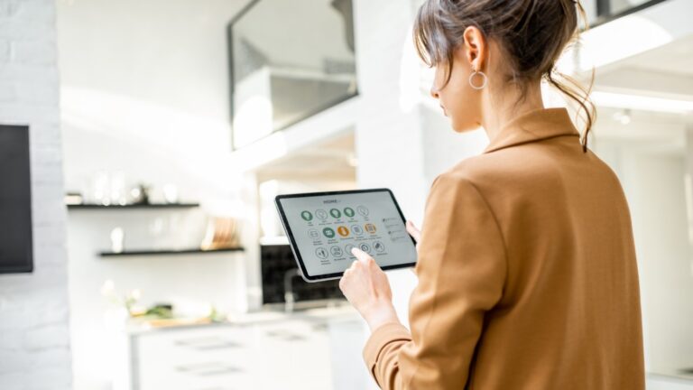 A woman using a smart device to connect with her smart home.
