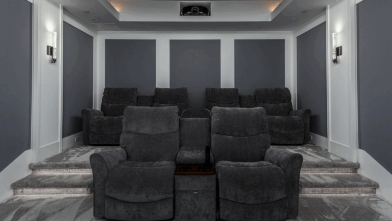 A modern home theater with four sets of luxury furniture.