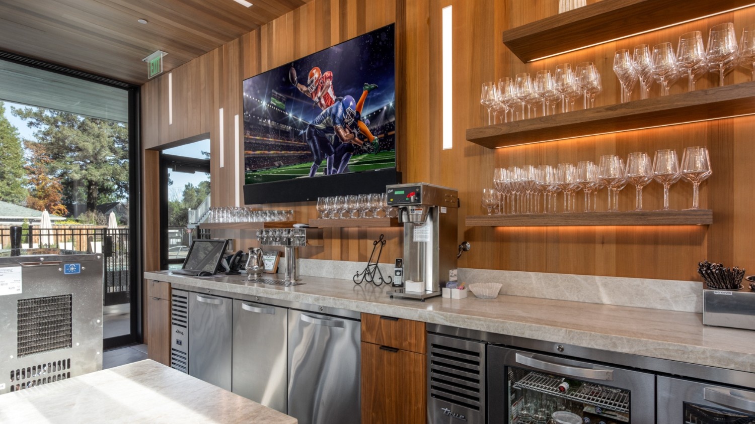 A modern wine bar with AV installations including a screen and lights.