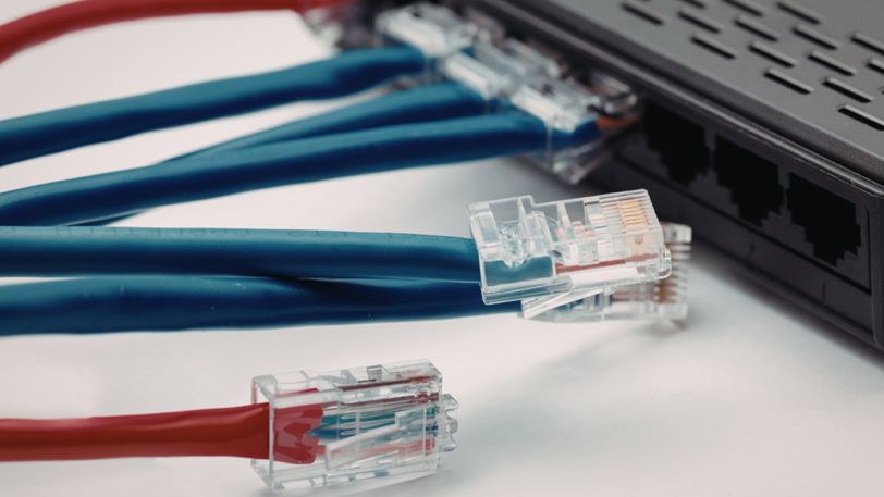 A close-up image of a networking panel with blue and red wires, some unconnected.