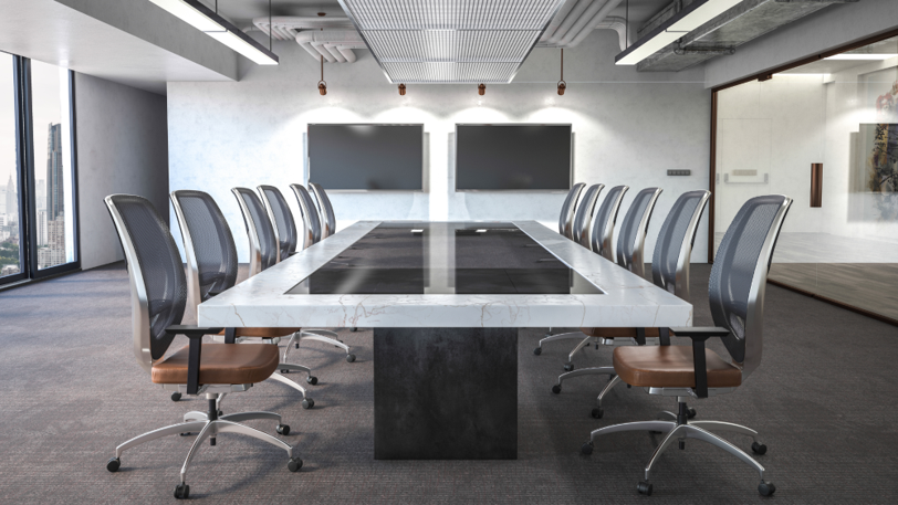 A modern boardroom space with televisions on the wall and a long, marble table.